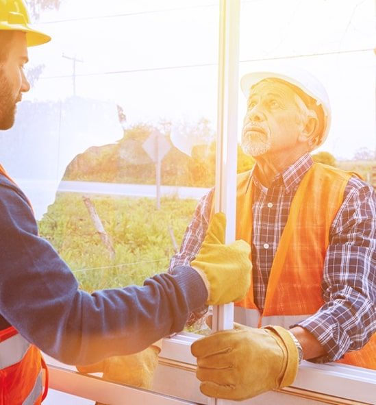 Two workers installing a window